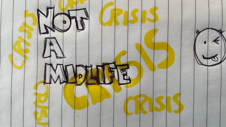A picture of a notebook with "NOT A MIDLIFE CRISIS" written on it